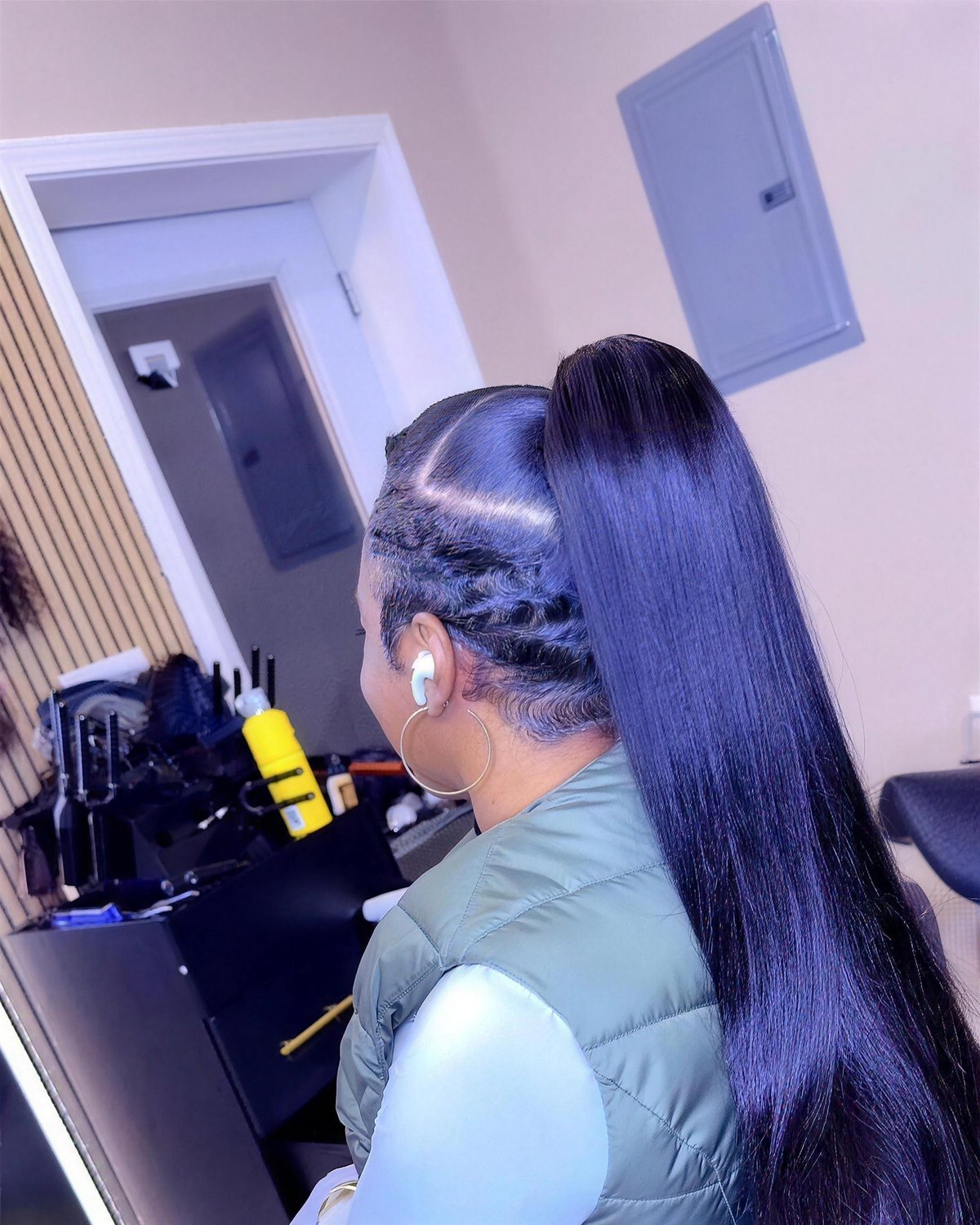 Sleek high ponytail with extensions, long and straight.